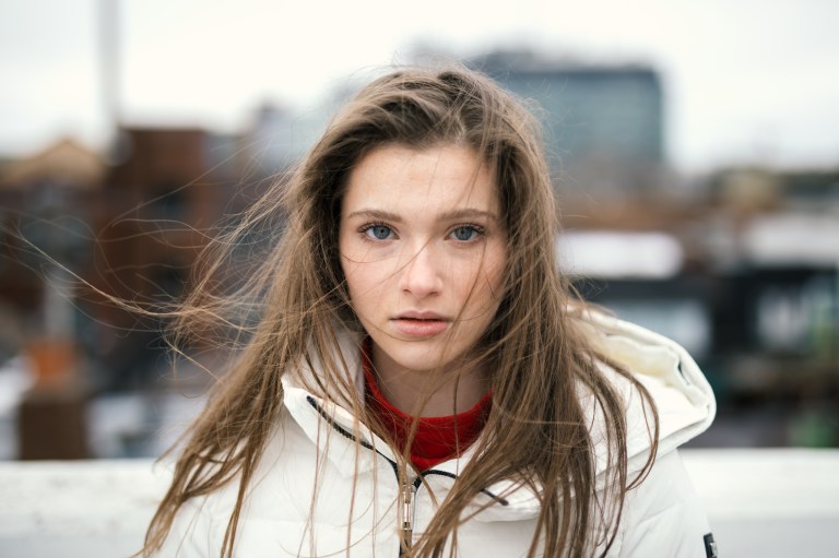 girl with a white coat and hair in her face