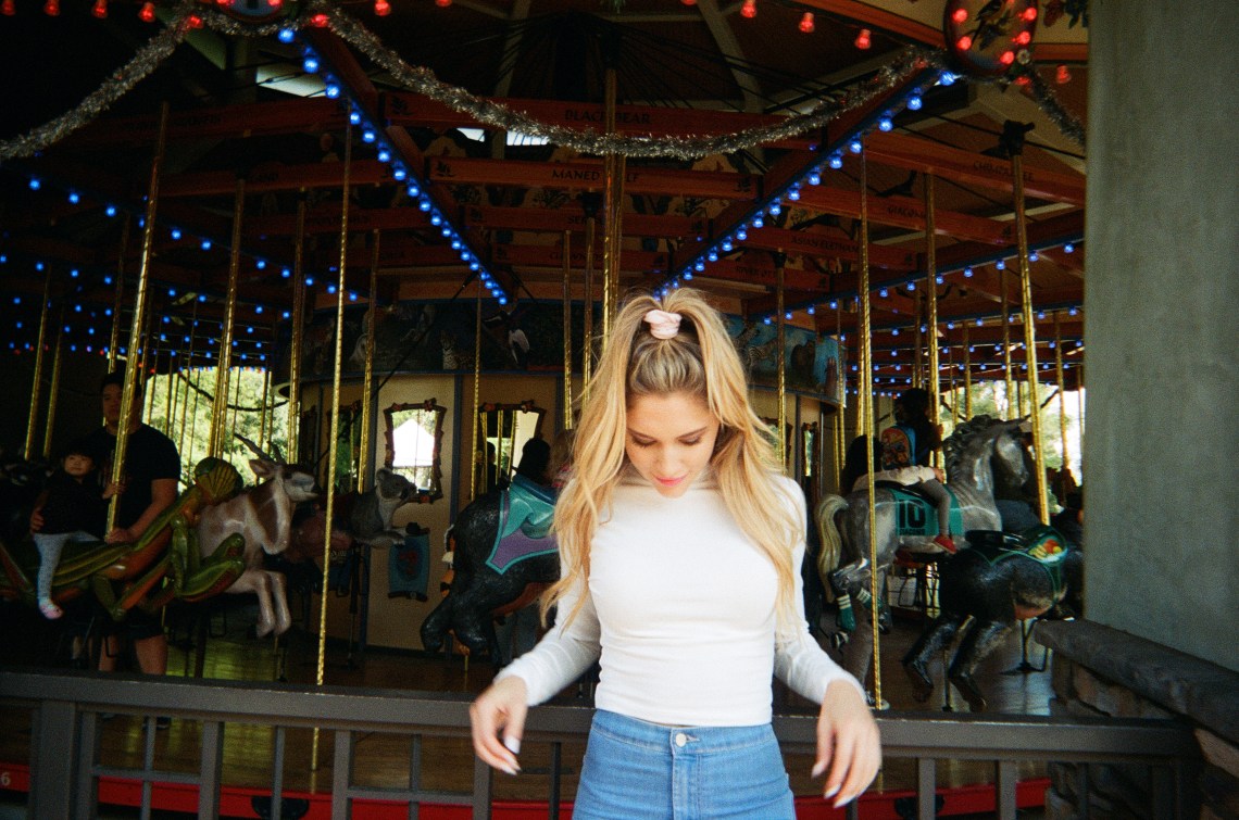 woman standing in front of carousel