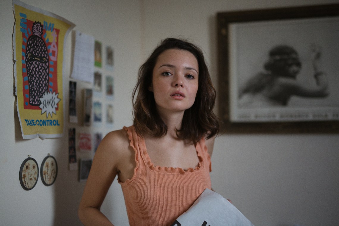 woman in peach tank top staring