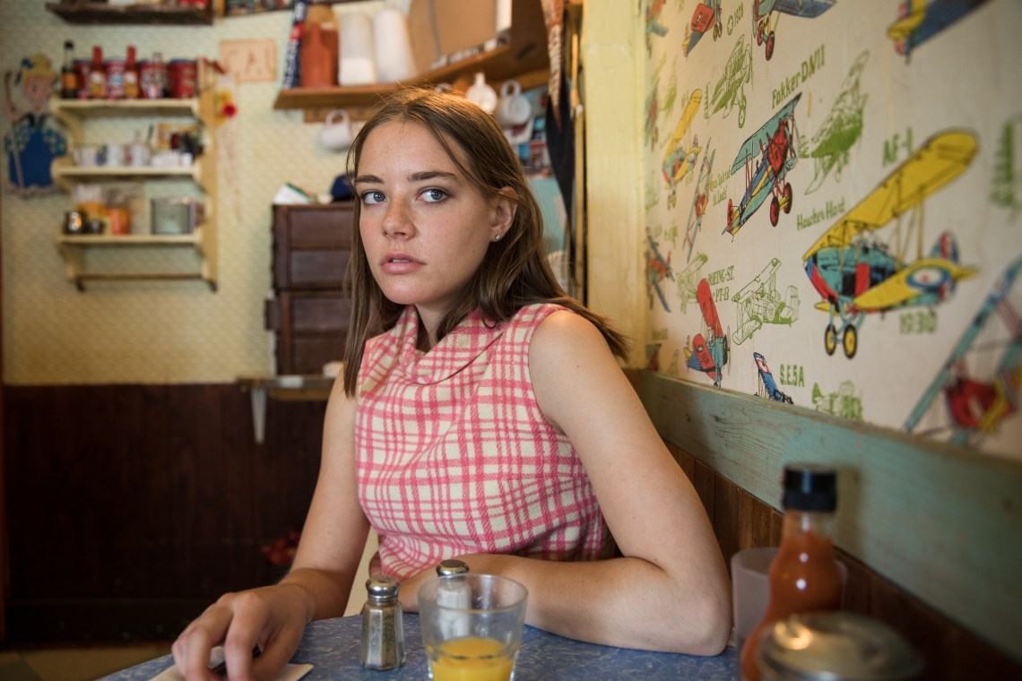 woman sitting in diner looking scared