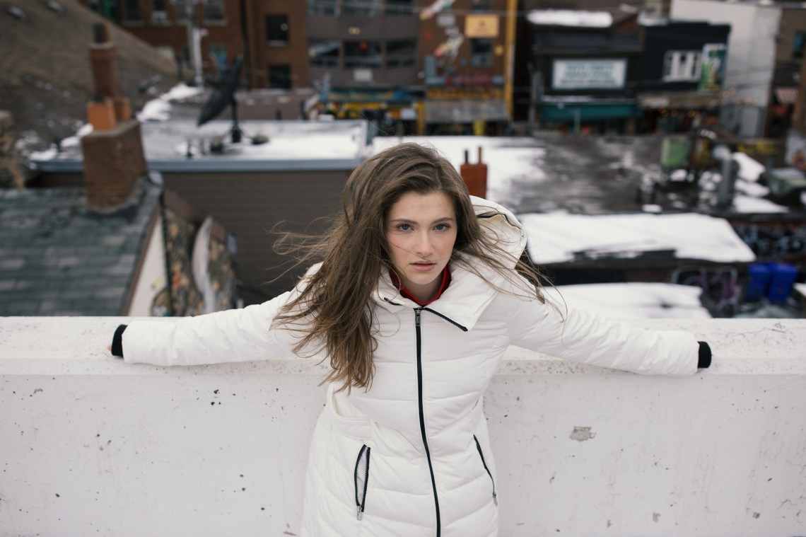 distressed looking girl in white winter coat