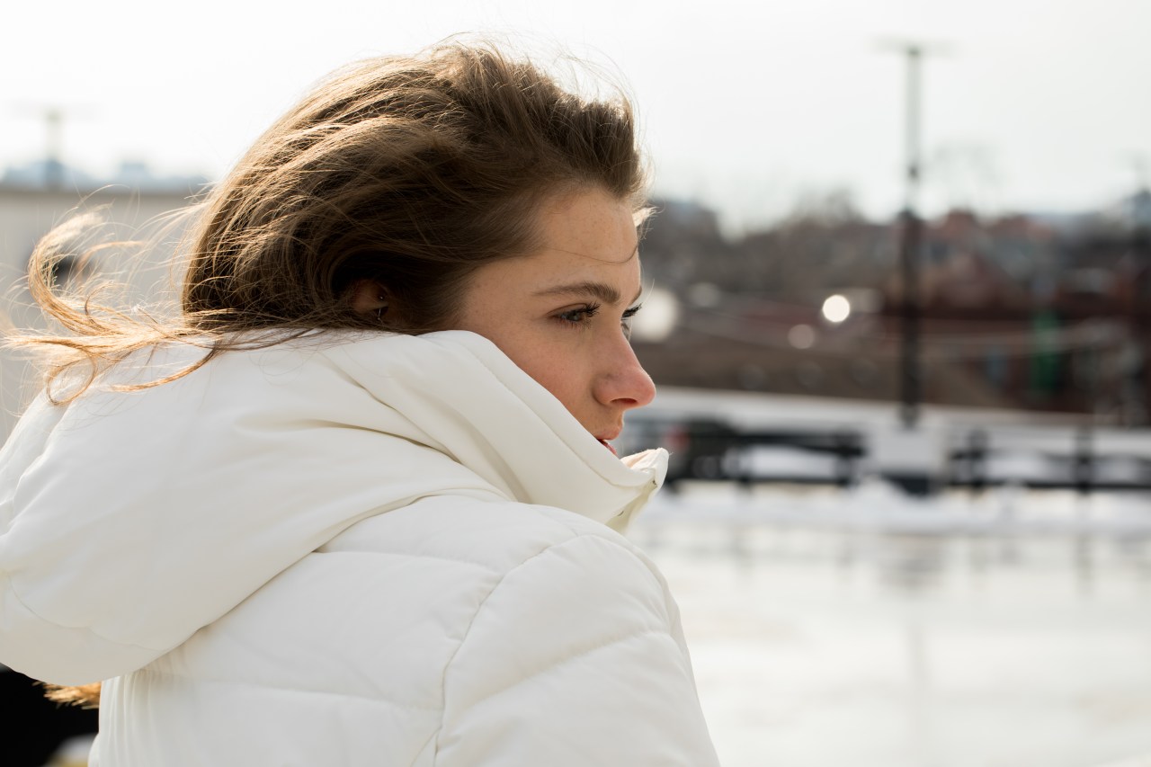 girl in white coat looking thoughtful