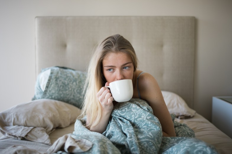 girl drinking coffee in bed