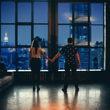 couple facing window holding hands