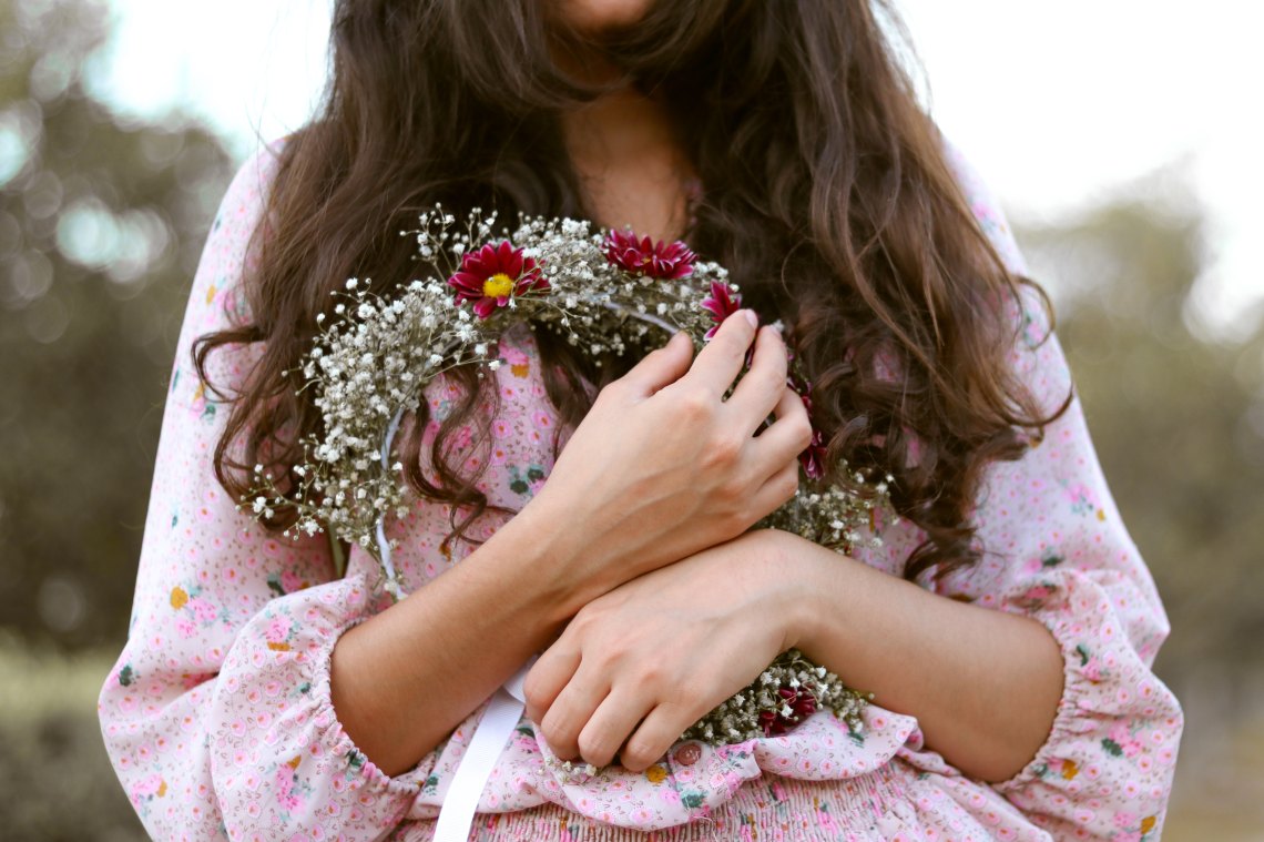 Woman holding flowers to her chest because period pains are awful