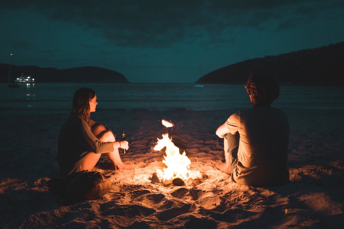 couple sitting together at bonfire
