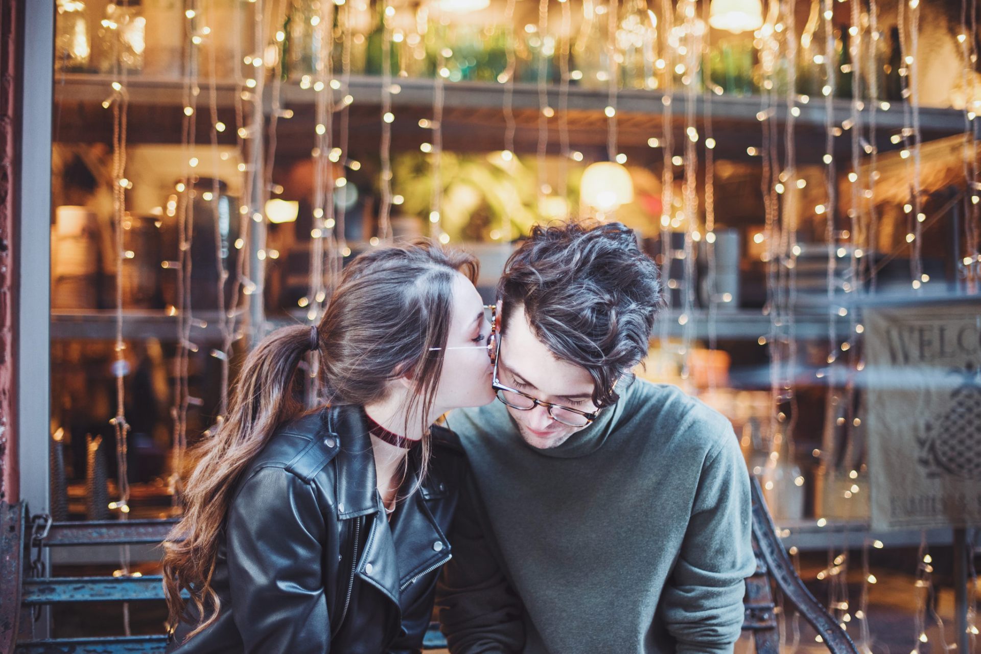 couple kissing in front of lights