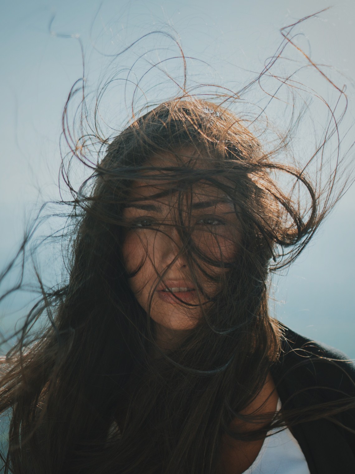 woman standing in sun with windblown hair