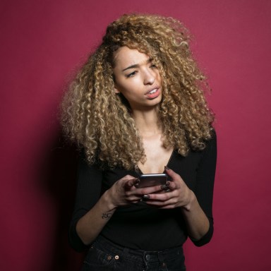 A woman looks up from her phone, confused and annoyed at the stupid person texting her