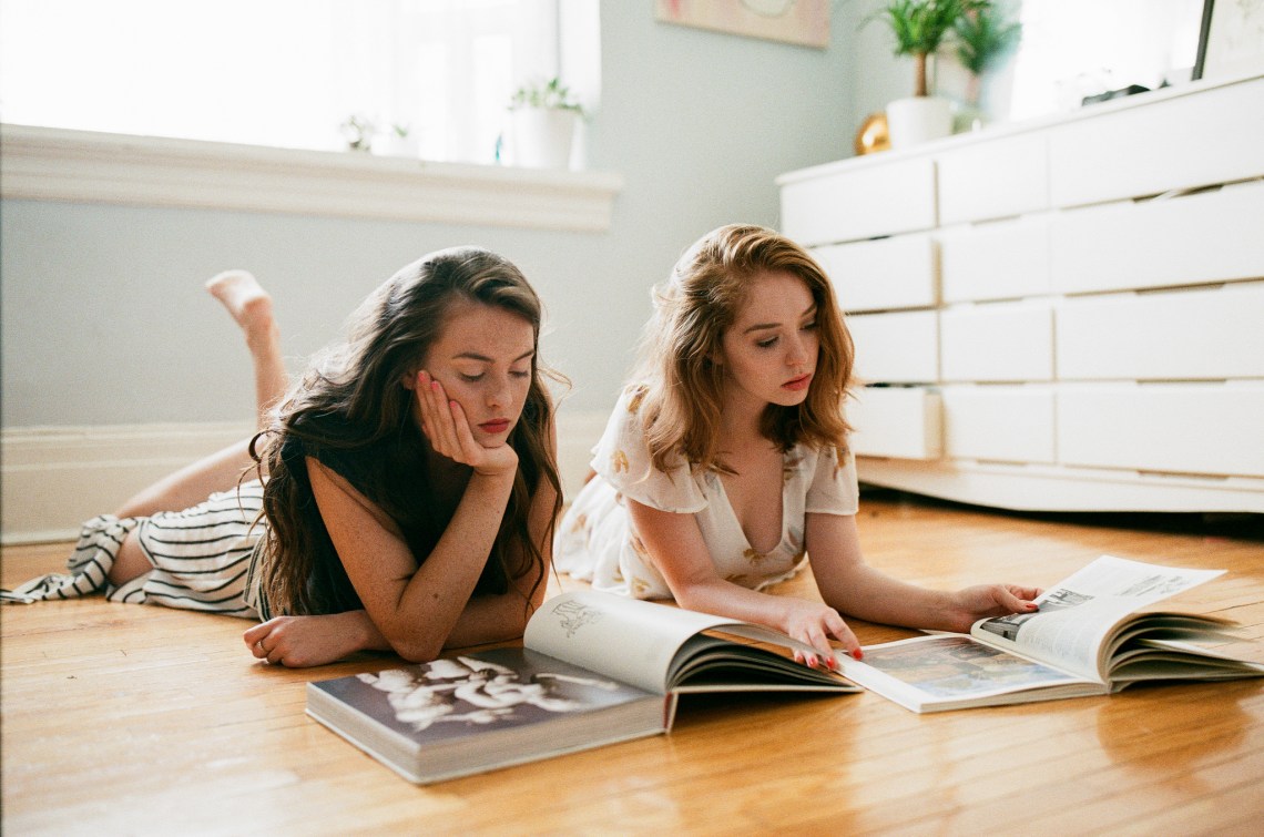 two friends reading on the floor
