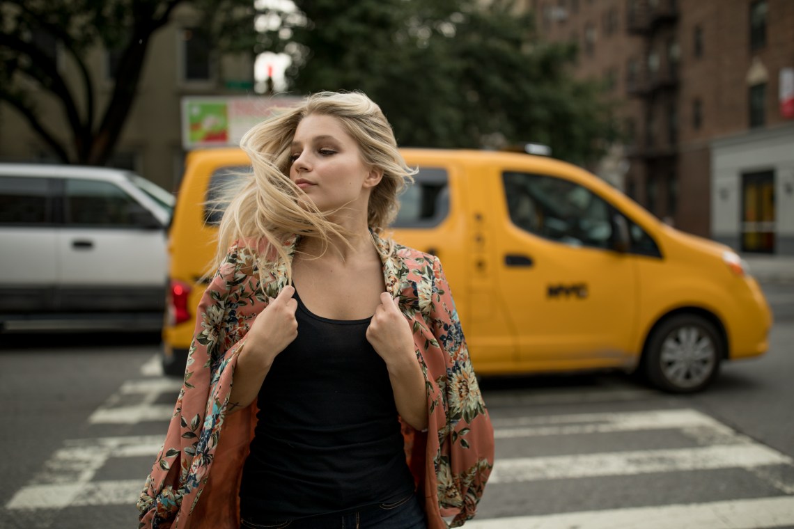 woman walking in front of taxi tossing hair