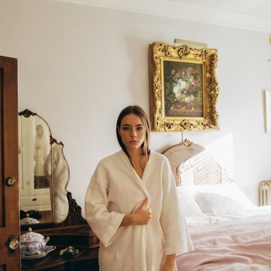 girl standing in robe in hotel room