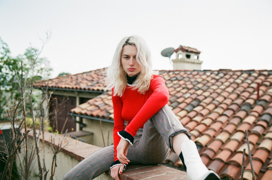 woman in red sweater sitting on roof