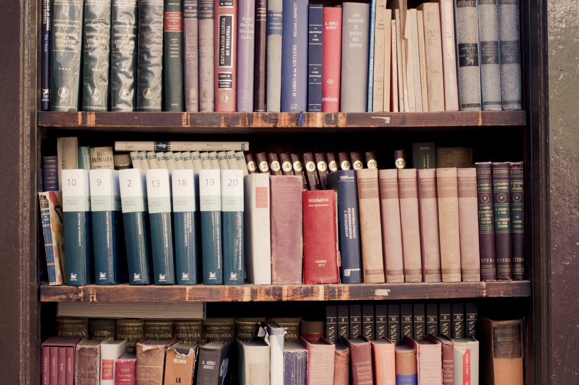 Old books lined on a bookshelf