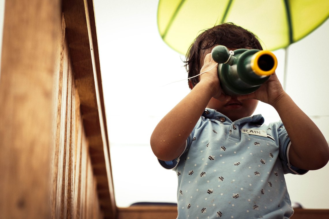 A little kid looks through a telescope