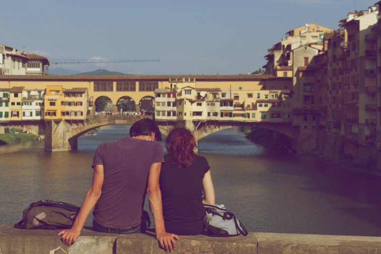 couple sitting on bridge together