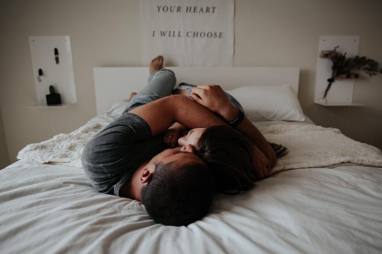 a man and woman cuddling together in bed