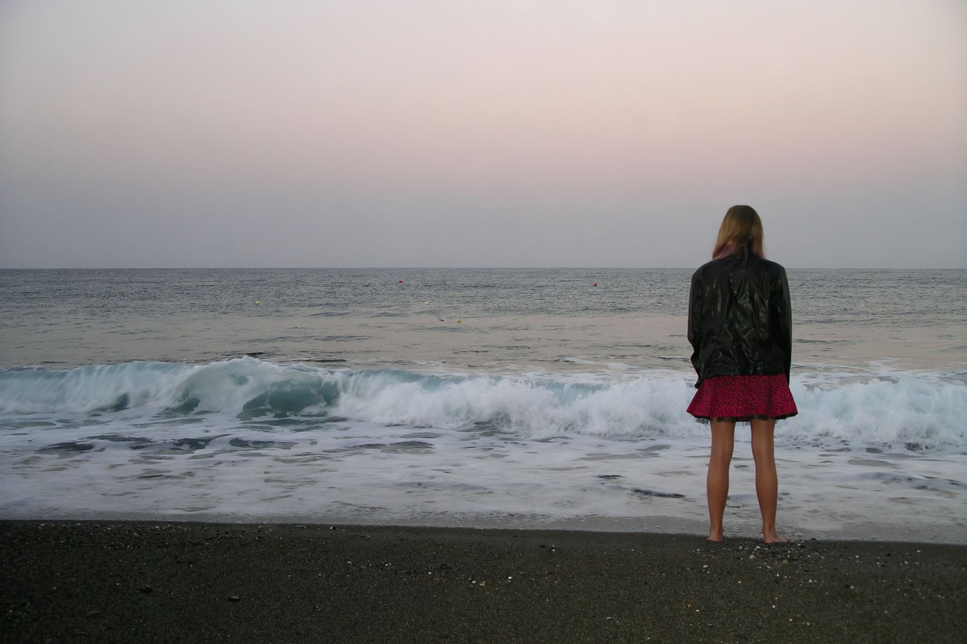 woman standing on shore looking at sea