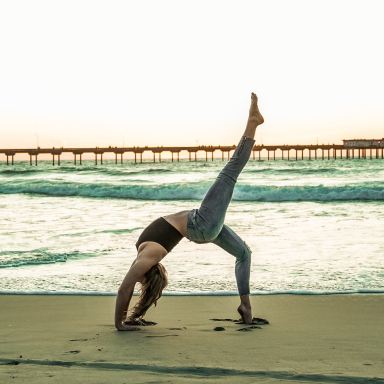 woman doing yoga pose on seashore