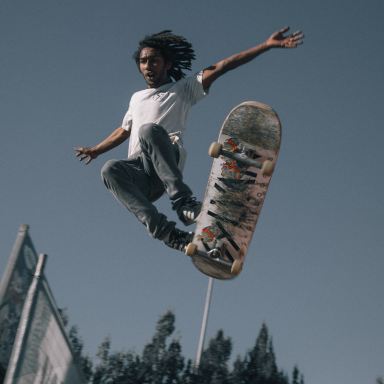 man wearing white T-shirt using skateboard