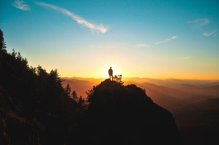 silhouette of man standing on mountain