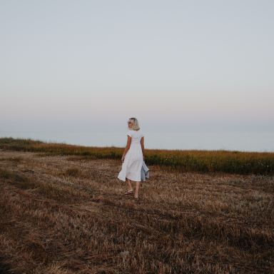 woman walking on brown grass field