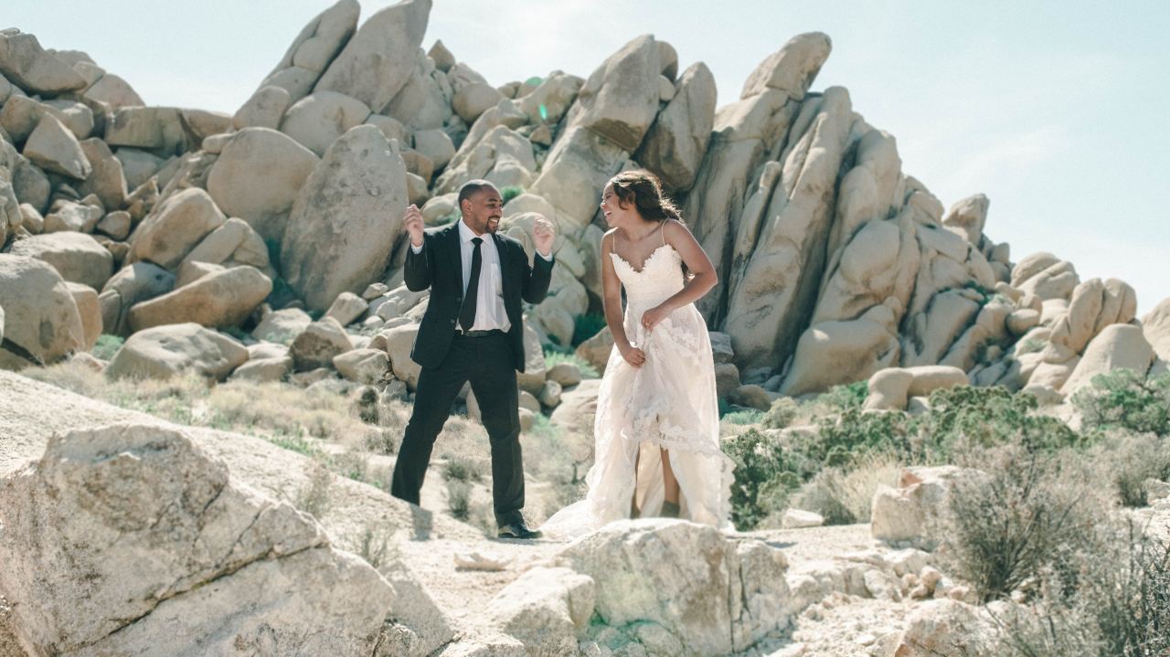 newly couple standing on rocks outside