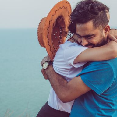 couple hugging on high ground overlooking the sea