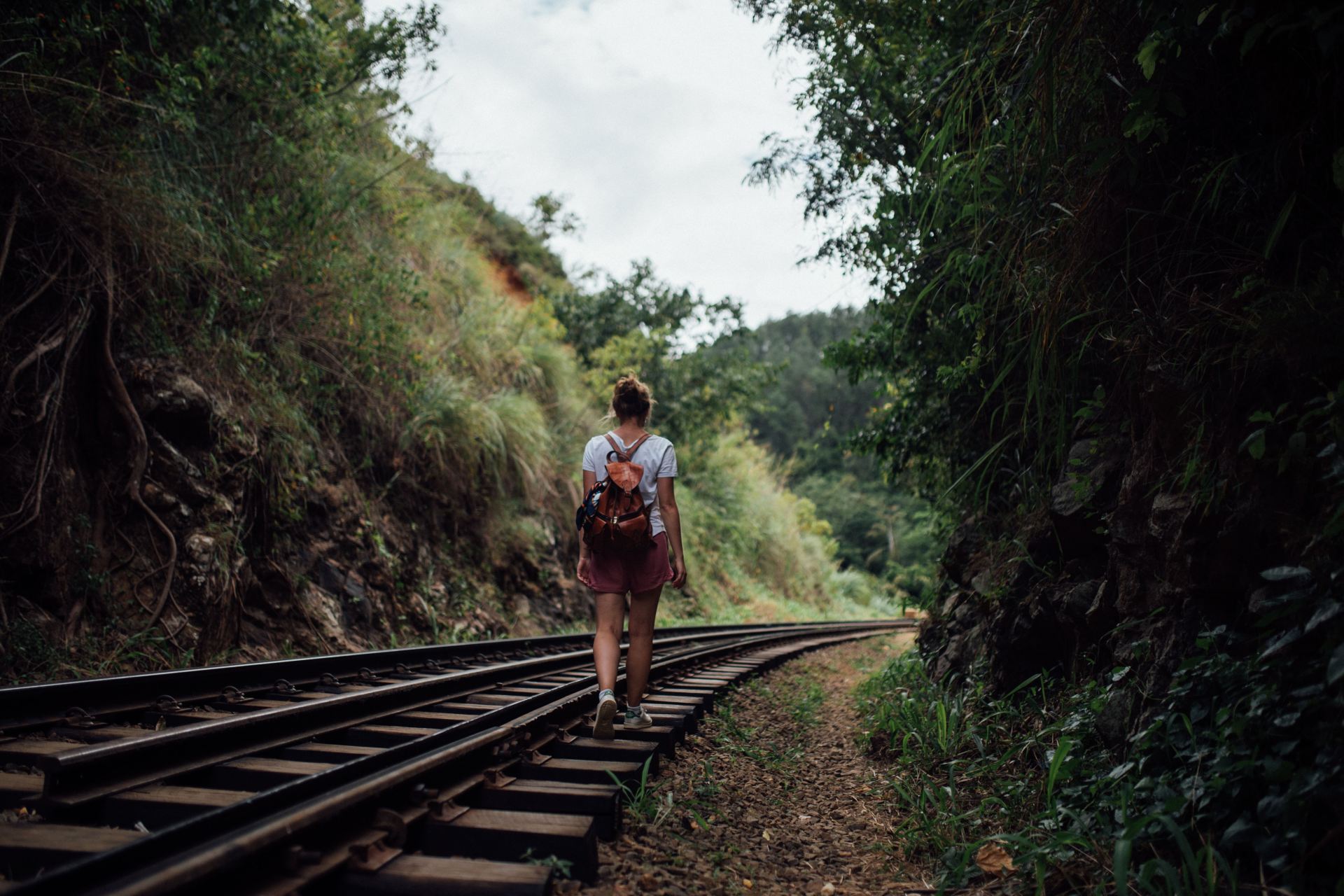 woman walking on train trail at daytime