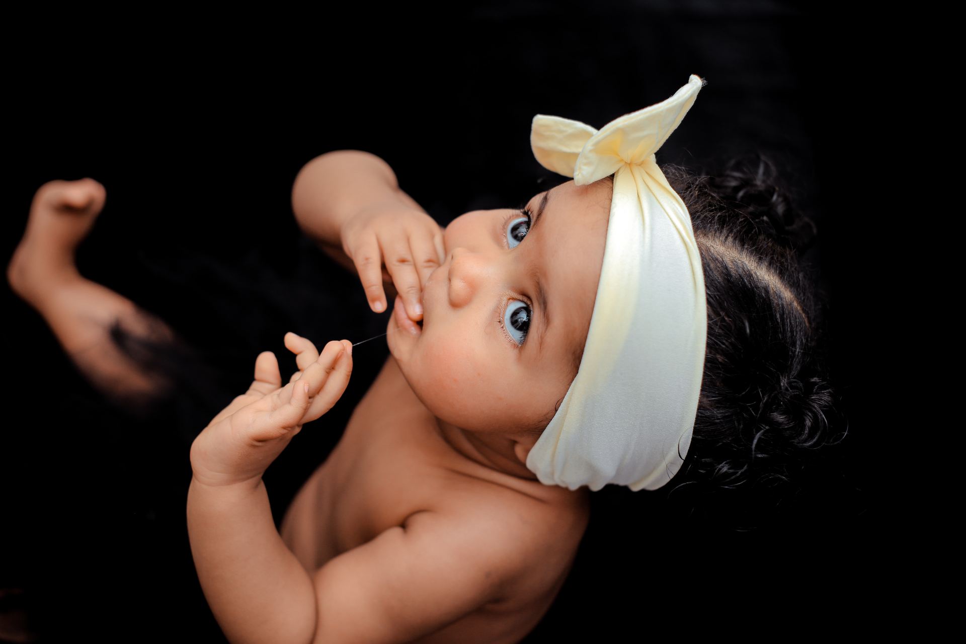 toddler wearing yellow ribbon close-up photography
