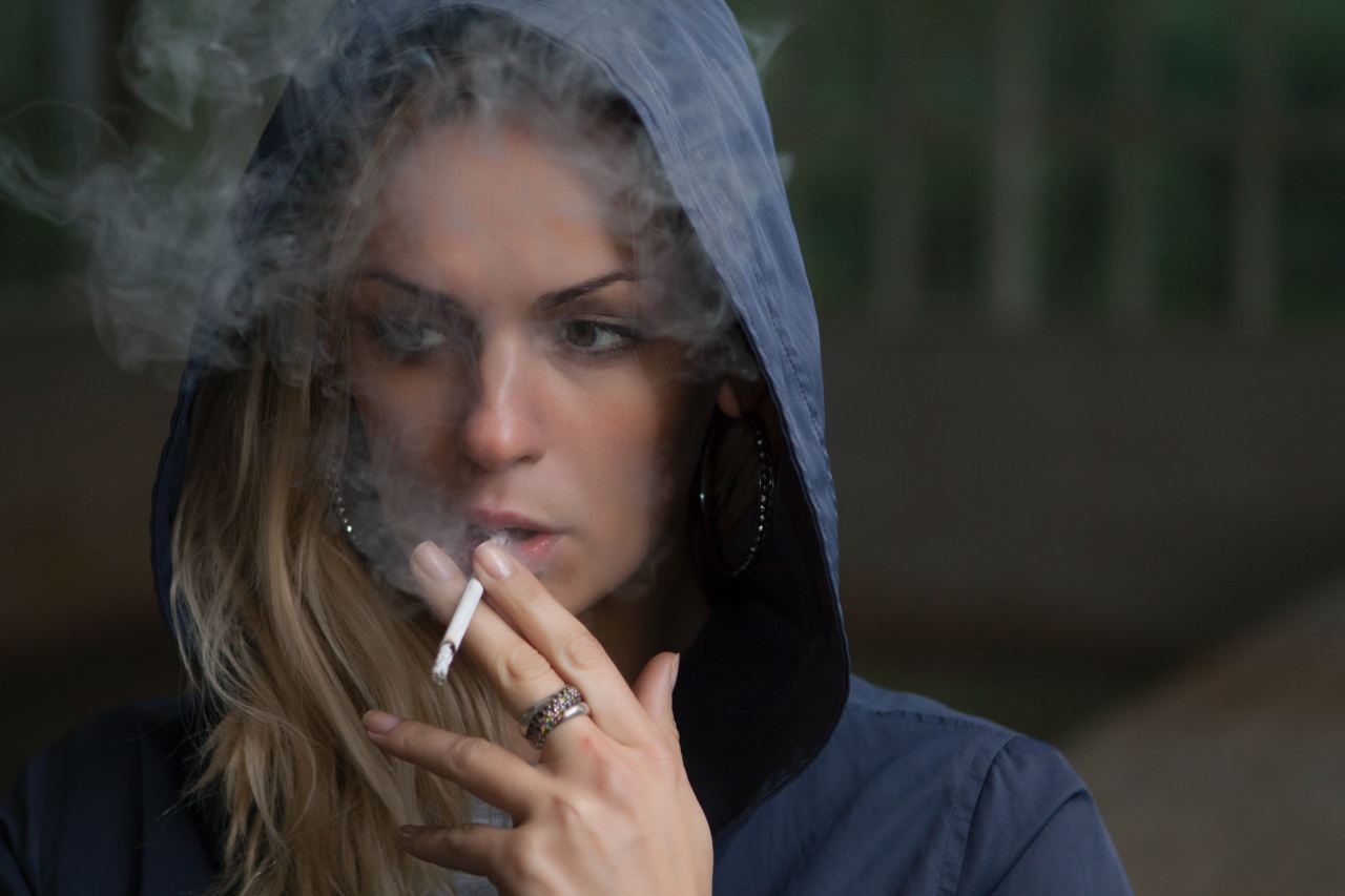 woman wearing hoodie while holding cigarette