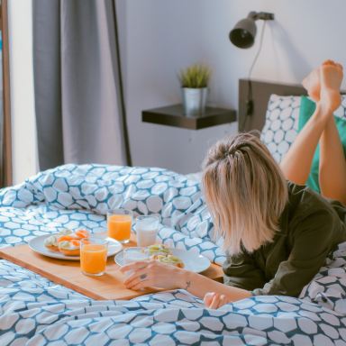 woman lying on bed white holding board
