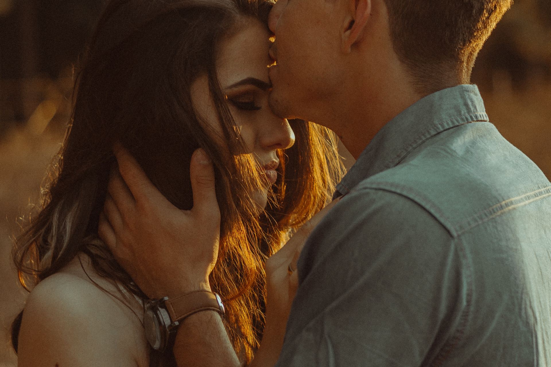 man kissing woman forehead