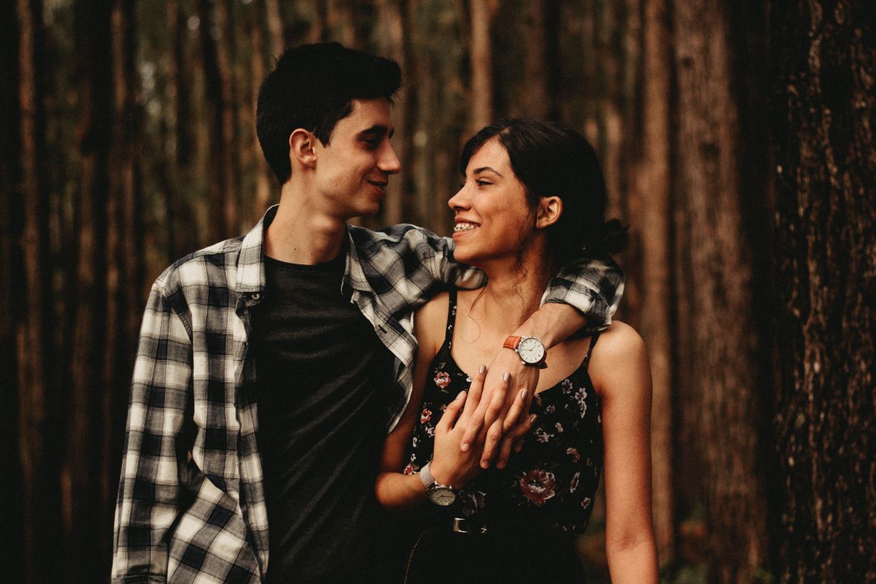 man wrapping arm on woman facing each other