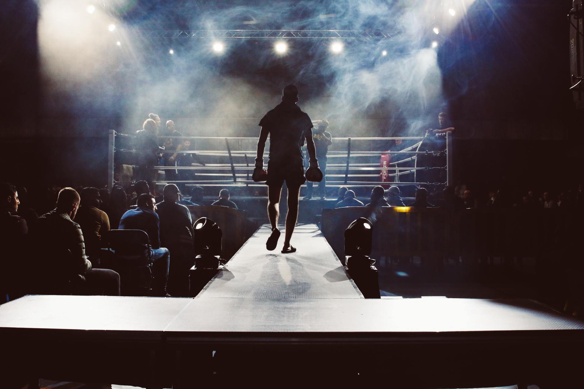 man standing and walking going on boxing ring surrounded with people photo