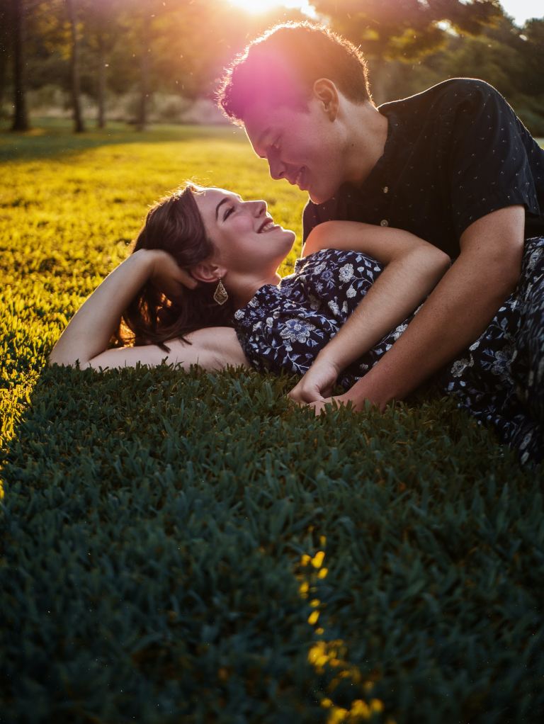 man and woman lying on green grass field during daytime