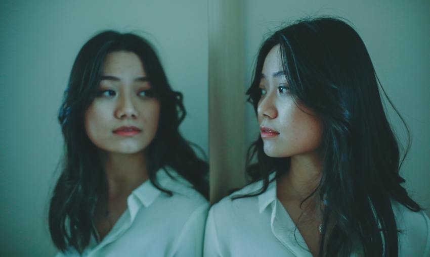 Young Asian female looking at reflection