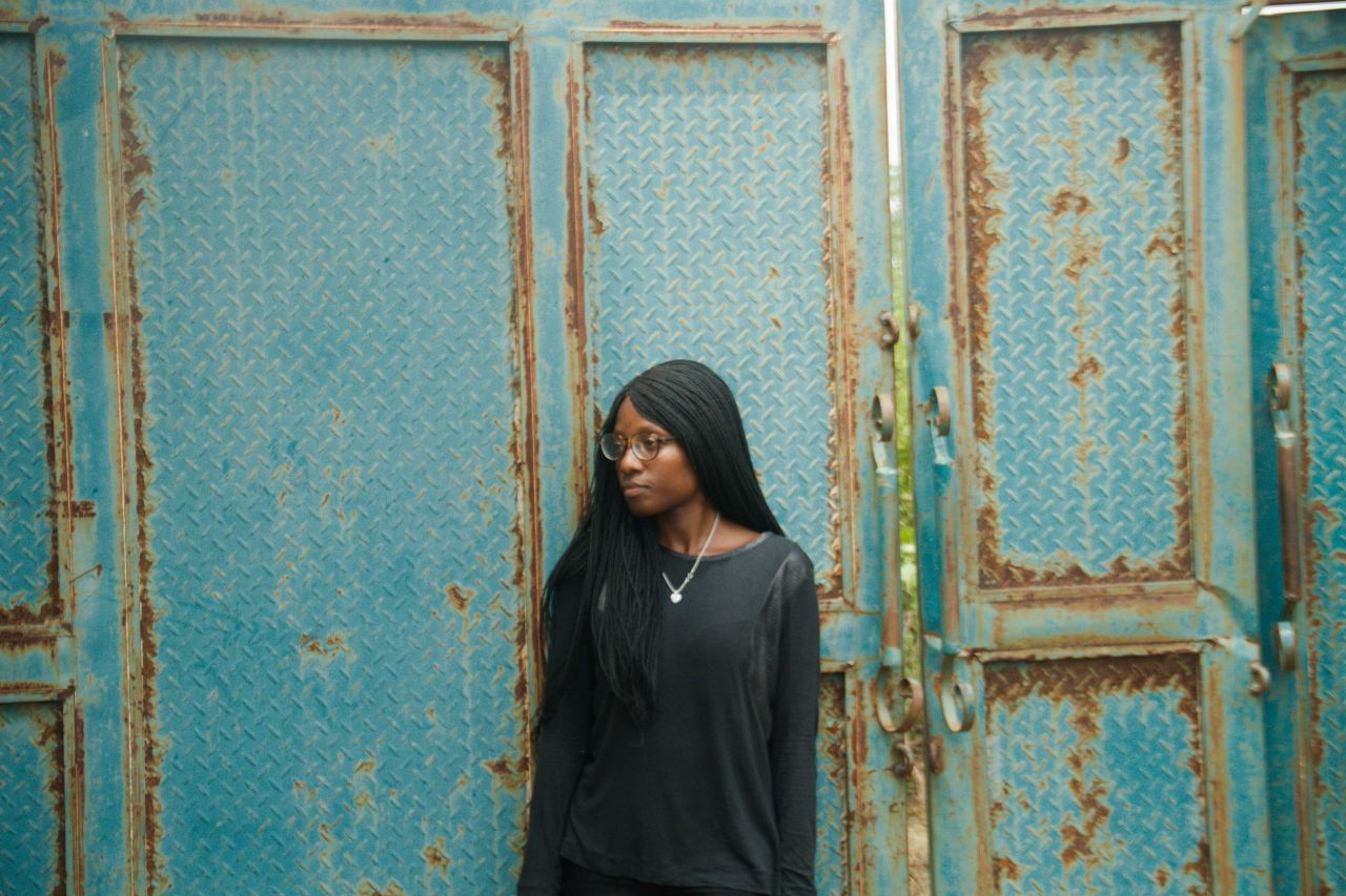 woman leaning on blue surface at daytime