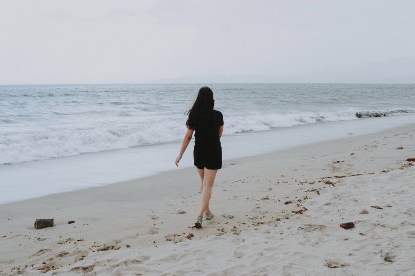 woman walking on beach shore