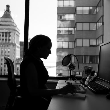 grayscale photography of woman sitting in front of a computer