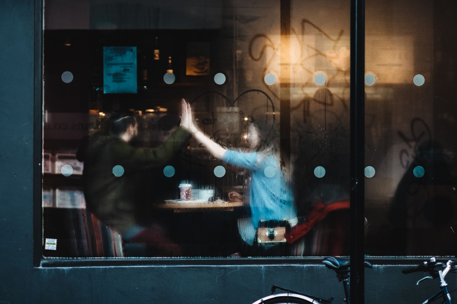 man and woman clapping each other hands inside the cafe