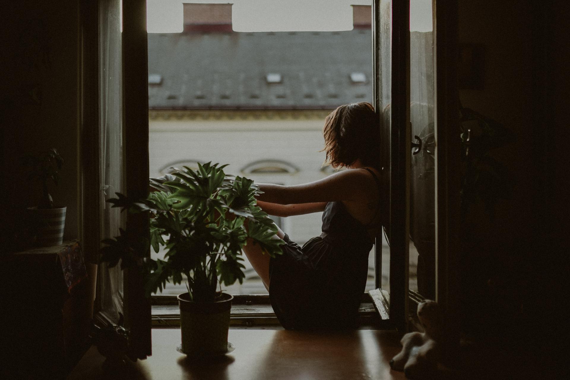 Woman leaning on door looking outside photo