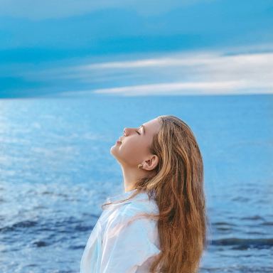 woman in white shirt standing near sea during daytime