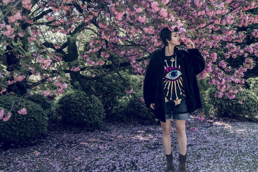 woman standing under cherry blossom tree