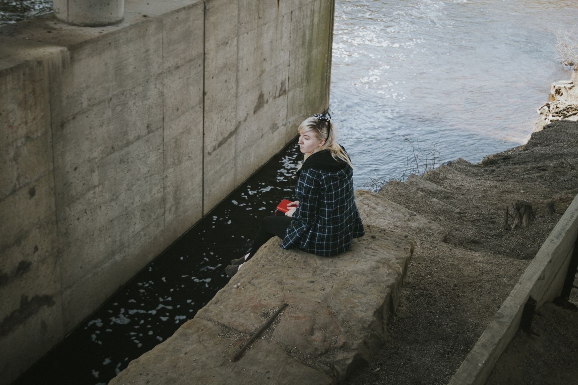 woman sitting beside river
