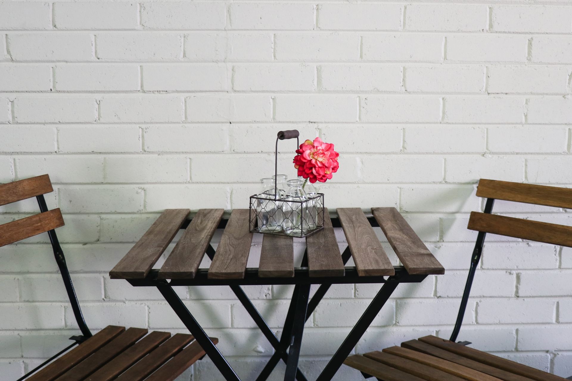 brown folding table and chairs by the white wall