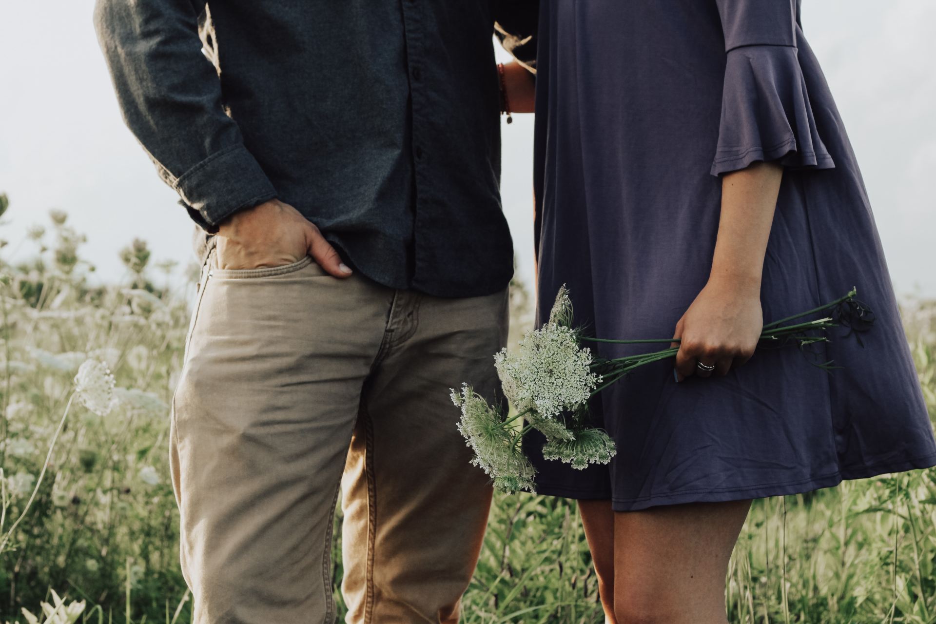 man and woman standing on white flower field at daytime