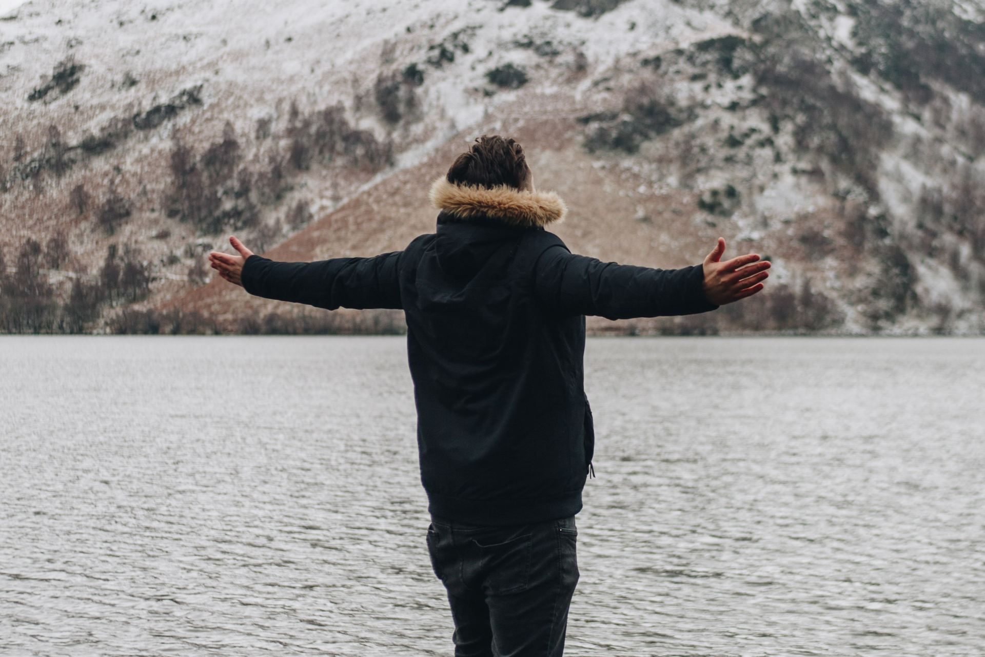 person standing on rock near body of water