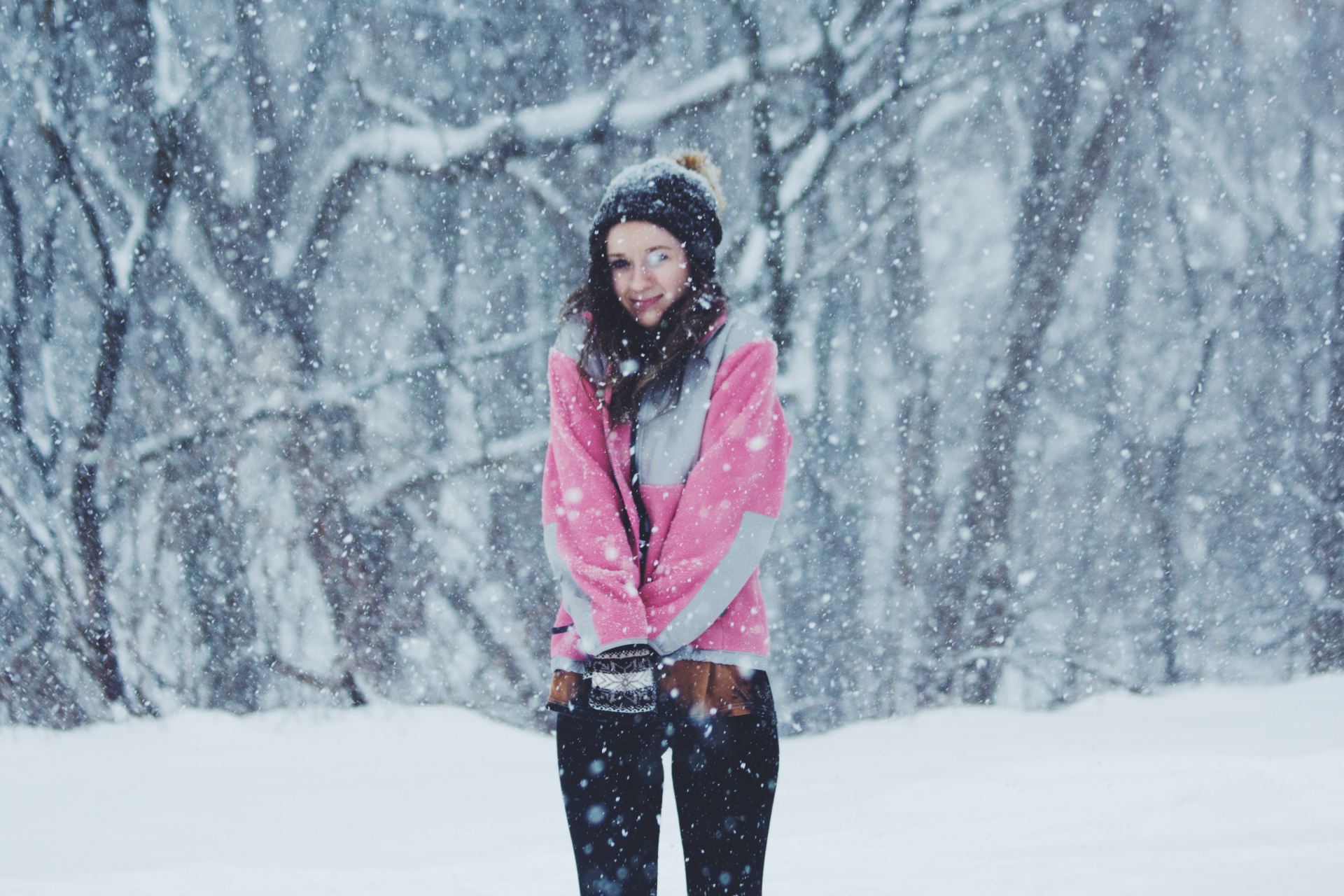 woman wearing pink jacket standing on snow ground