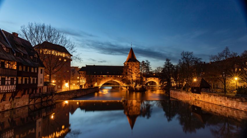 brown concrete building near body of water during night time